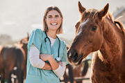 Smiling veterinarian standing beside a horse – professional equine care and wellness support for healthy, happy horses.